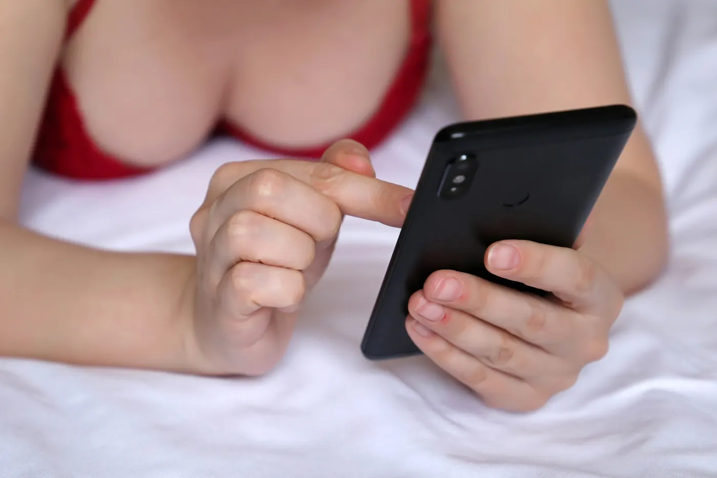 Femme composant le numéro audiotel sexe sur son téléphone